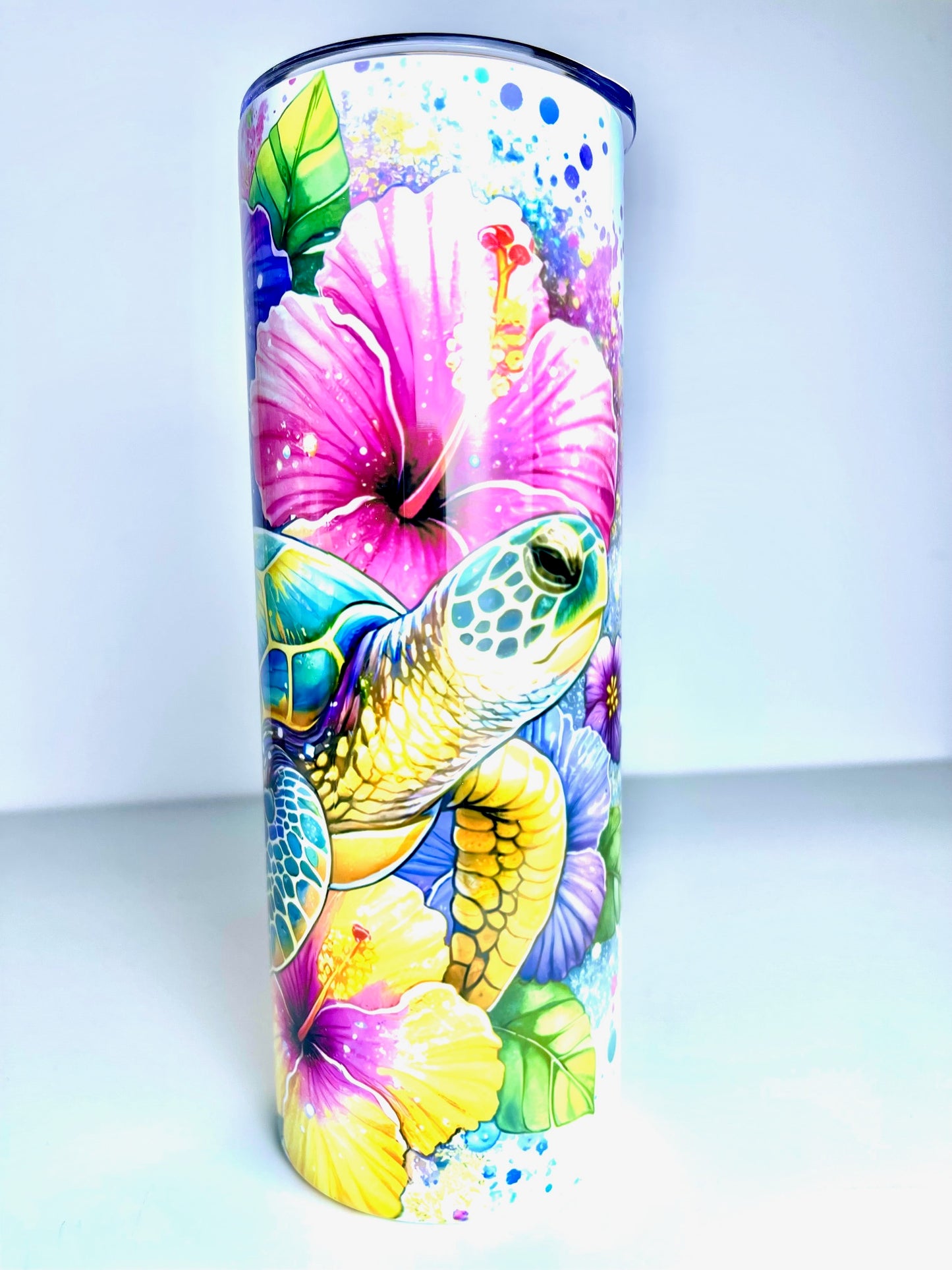 Tumbler with a colorful design of a turtle and flowers on a white background
