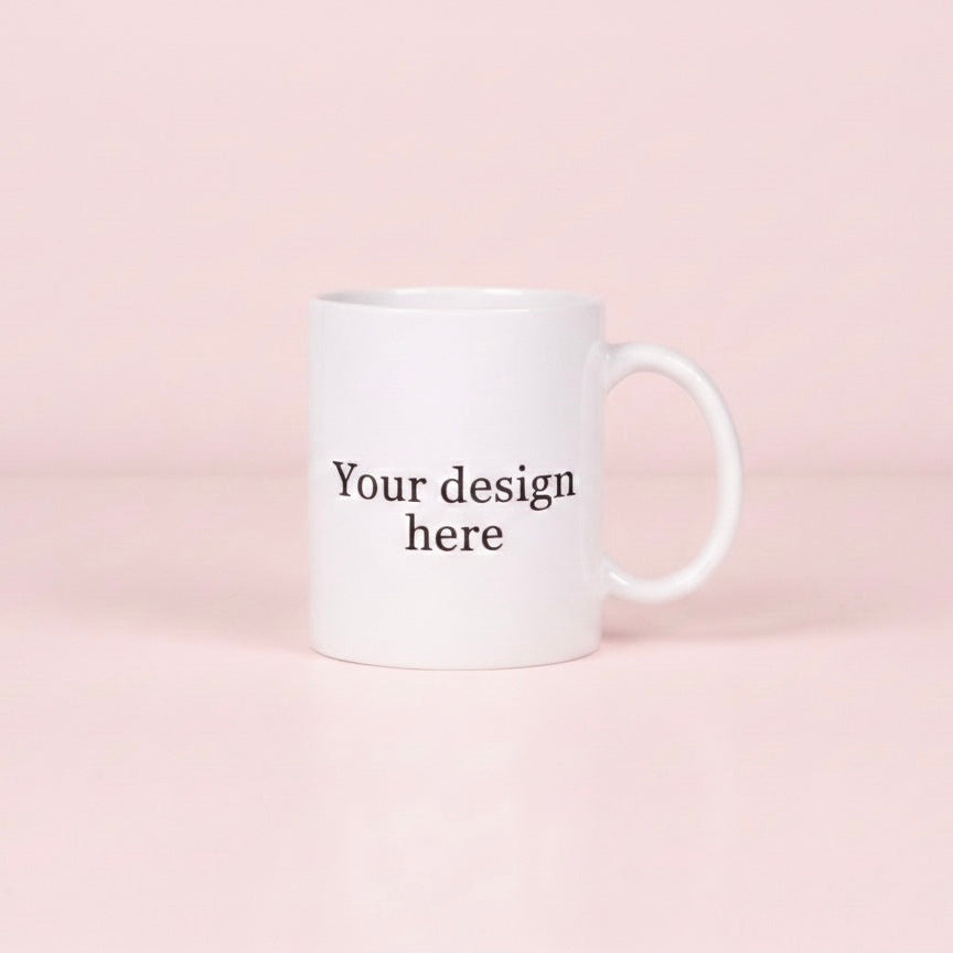 White mug with 'Your design here' text on a pink background